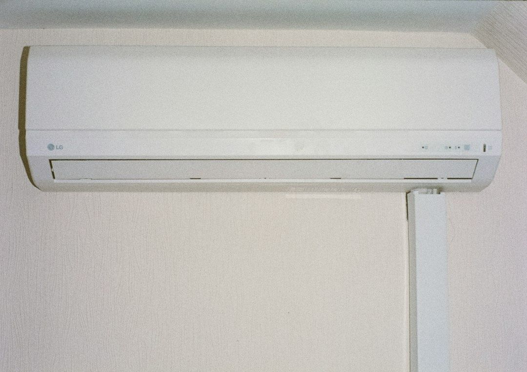 Vit LG-luftvärmepump monterad högt på en vägg